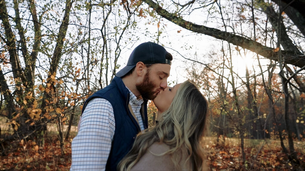 Couple kissing under trees in autumn 