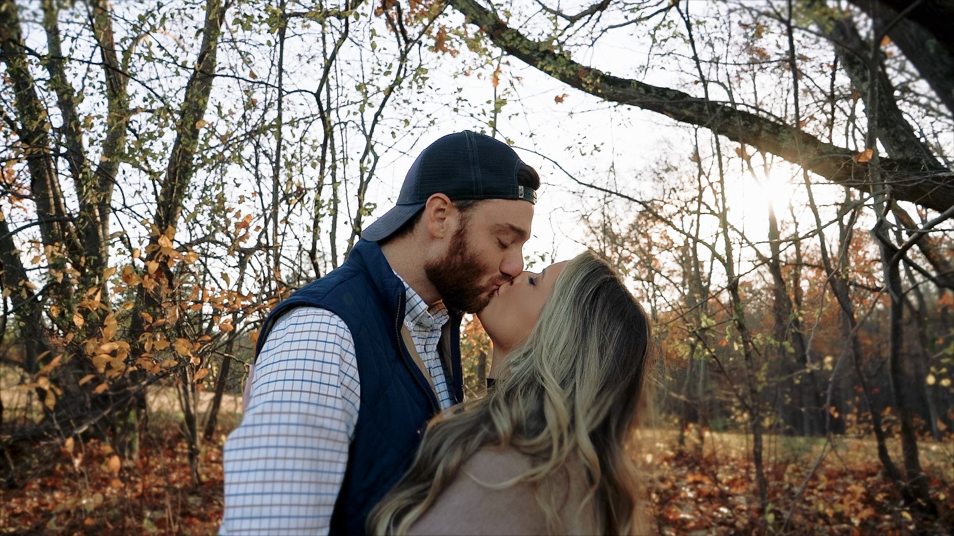 Couple kissing under trees in autumn